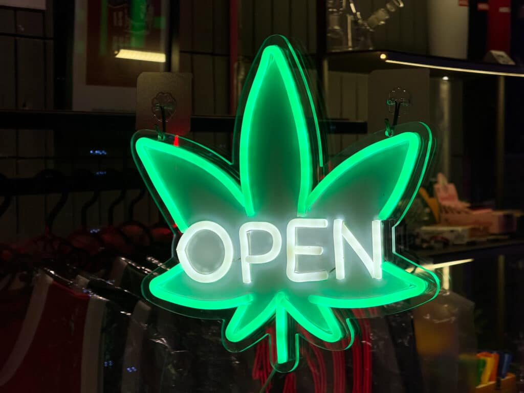 Bangkok, Thailand - July 24, 2025: Neon cannabis leaf open sign glowing outside shop on Khao San Road